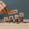 Hand putting wooden cube and inflation word a on coins in idea for FED consider interest rate hike, world economics, and inflation control, US dollar inflation