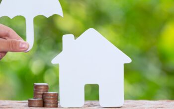 World Habitat Day,close up picture of a pile of coins and a model house